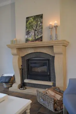 a living room with a fireplace with two candles at De Staberg in Bilzen