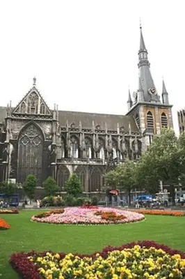 a large cathedral with a flower garden in front of it at Appartement Au Coeur de Liege in Liège