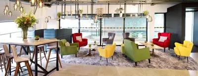 a dining room with colorful chairs and a table at Park Inn By Radisson Hasselt in Hasselt