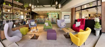 a room with colorful chairs and tables in a store at Park Inn By Radisson Hasselt in Hasselt