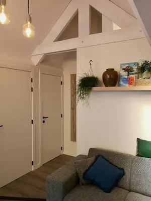 a living room with a couch and a door at Vakantieverblijf Volmolen B&B in Maaseik