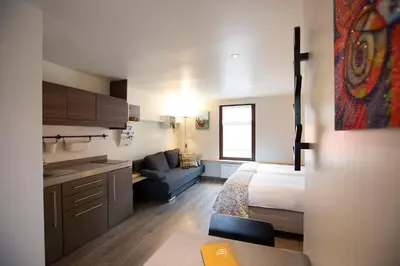 a small room with a bed and a couch and a kitchen at Vakantieverblijf Volmolen B&B in Maaseik