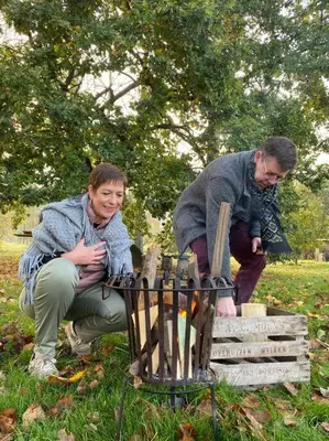 a man and a woman standing next to a grill at De Pluktuin in Kortessem
