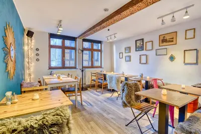 a restaurant with tables and chairs and windows at Chez Mamy in Liège