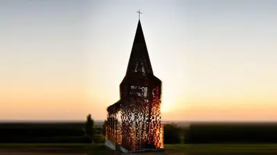 a tall building with lights on it at sunset at 't Poorthof in Borgloon