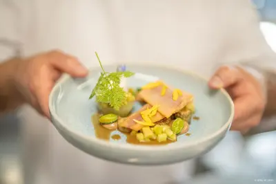 a person holding a white plate of food at La Ferme du Hélivy in Jalhay