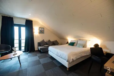 a hotel room with a bed and a couch at Smart Bnb - Hotel Battice in Battice