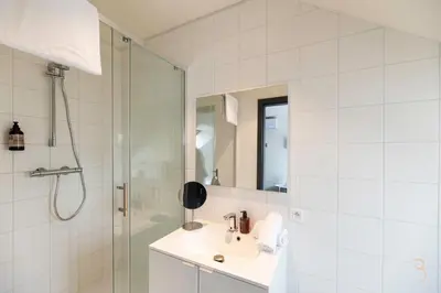 a white bathroom with a sink and a shower at Smart Bnb - Hotel Battice in Battice