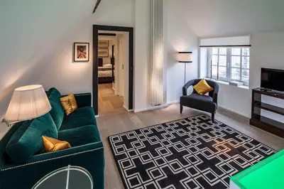 a living room with a green couch and a chair at Faubourg Saint Martin in Liège