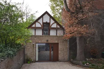 a brick house with a door and a tree at Maisonnette in Liège