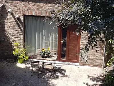 a patio with chairs and a window with flowers in it at Maisonnette in Liège