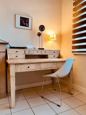 a wooden desk with a chair and a lamp at Fenêtre sur le Standard de Liège in Ougrée