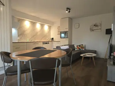 a living room with a table and chairs and a couch at Den 1 Hengelhoef in Houthalen-Helchteren