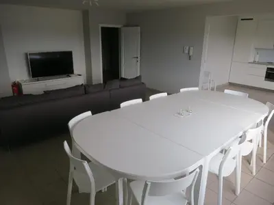 a living room with a white table and white chairs at De Vlier - Vakantiewoningen in Maasmechelen