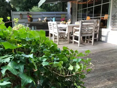 a patio with a table and chairs on a deck at Chalet Relax in Zutendaal