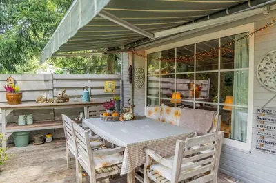 a table and chairs on the porch of a house at Chalet Relax in Zutendaal