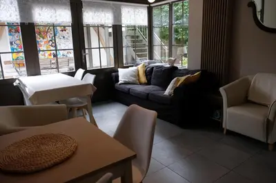 a living room with a couch and chairs and windows at Abeljano in Hasselt