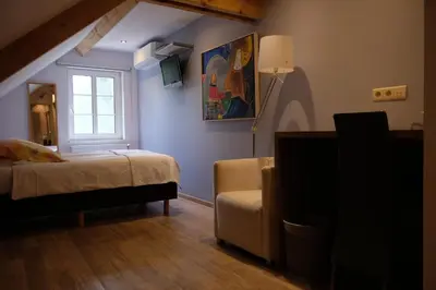 a bedroom with a bed and a window and a chair at Abeljano in Hasselt