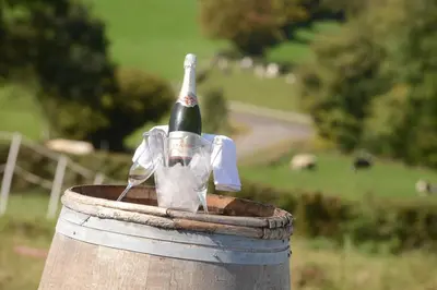 a bottle of wine sitting on top of a barrel at Les Coteaux du Vinave in Herve