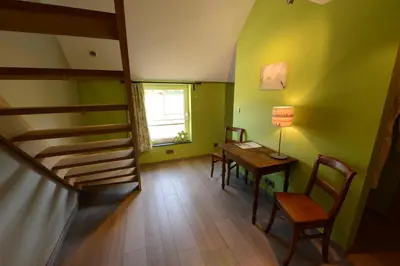 a room with a table and chairs and a staircase at Les Coteaux du Vinave in Herve