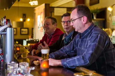a group of men sitting at a bar at Hotel De Spaenjerd in Kinrooi