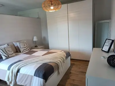 a bedroom with a large bed and a chandelier at InContri in Liège
