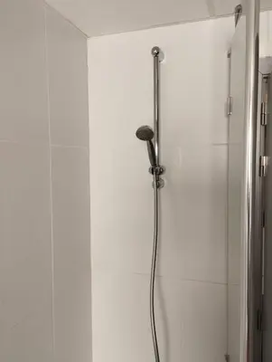a shower in a bathroom with white walls at Cosy Corner in Lommel