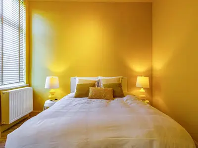 a bedroom with a large white bed with two lamps at Luxurious holiday home in Heers with terrace in Mettekoven