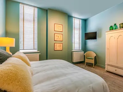 a bedroom with green walls and a bed and windows at Luxurious holiday home in Heers with terrace in Mettekoven