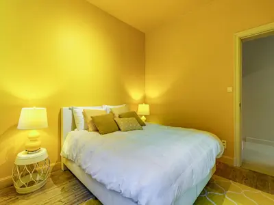 a bedroom with a large bed with yellow walls at Luxurious holiday home in Heers with terrace in Mettekoven