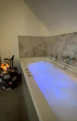 a bathroom with a tub with blue lights in it at De Verborgen Parel B&B in Borgloon