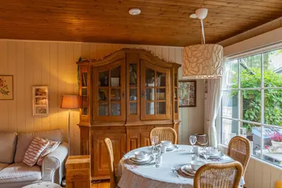 a dining room with a table and a cabinet at Chalet Luxe in Zutendaal