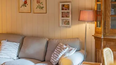a living room with a couch and a lamp at Chalet Luxe in Zutendaal