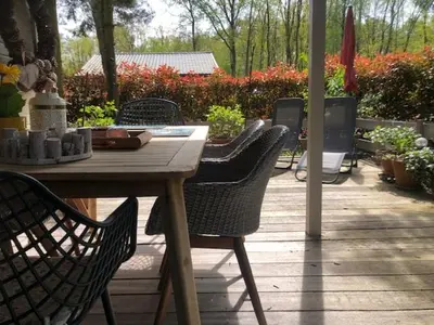 a wooden table and chairs on a patio at Chalet Luxe in Zutendaal