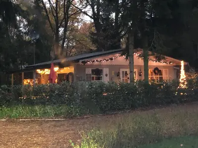 a house lit up at night with lights at Chalet Luxe in Zutendaal