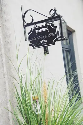 a sign hanging on the side of a building at Bed and breakfast Mooi Achel in Achel