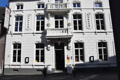 a white building with a door and a balcony at B&B Huize Briers in Bilzen