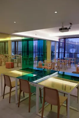 a dining room with tables and chairs and windows at Corbie Lommel Ring in Lommel