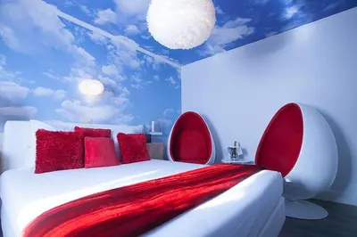 a bedroom with a white bed with red pillows at Villa Valentino in Hasselt