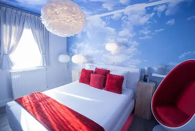 a bedroom with a white bed with red pillows at Villa Valentino in Hasselt