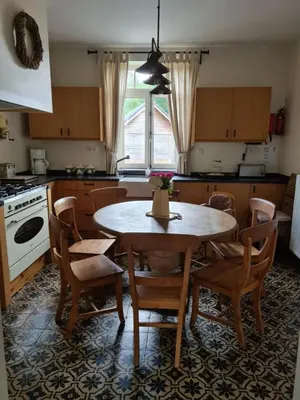 a kitchen with a wooden table and chairs and a table at Vakantiewoning Tivoli in Dilsen-Stokkem