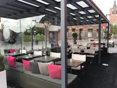 a restaurant with tables and chairs with pink pillows at Hotel De Boskar Peer in Peer