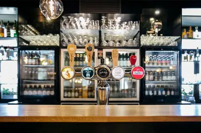 a bar with a bunch of bottles of alcohol at La Couronne in Welkenraedt
