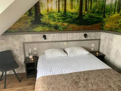 a bedroom with a bed with a painting on the wall at Hotel De Maaskant in Maaseik