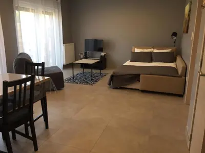 a bedroom with a bed and a couch and a table at Rentalis Flat in Liège