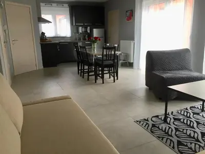 a living room and kitchen with a table and chairs at Rentalis Flat in Liège
