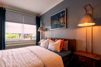 a bedroom with a bed and two lamps and a window at De Villo in Hasselt
