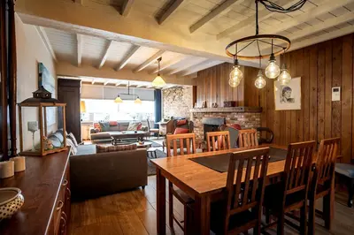 a dining room and living room with a table and chairs at De Villo in Hasselt