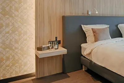 a bedroom with a bed and a night stand next to it at twee broeders in Riemst