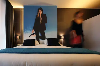 a poster of a woman standing on a bed at Hotel De Groene Hendrickx in Hasselt